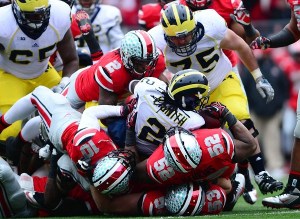 Nov 24, 2012; Columbus, OH, USA; Michigan Wolverines running back Vincent Smith (2) is tackled by the Ohio State Buckeyes defense in the fourth quarter at Ohio Stadium. Mandatory Credit: Andrew Weber-US PRESSWIRE