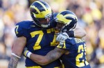 November 10, 2012; Ann Arbor, MI, USA; Michigan Wolverines offensive linesman Taylor Lewan (77) and wide receiver Roy Roundtree (21) celebrate a touchdown against the Northwestern Wildcats in overtime at Michigan Stadium. Michigan won 38-31.