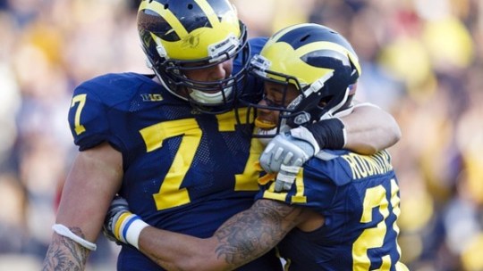 November 10, 2012; Ann Arbor, MI, USA; Michigan Wolverines offensive linesman Taylor Lewan (77) and wide receiver Roy Roundtree (21) celebrate a touchdown against the Northwestern Wildcats in overtime at Michigan Stadium. Michigan won 38-31.
