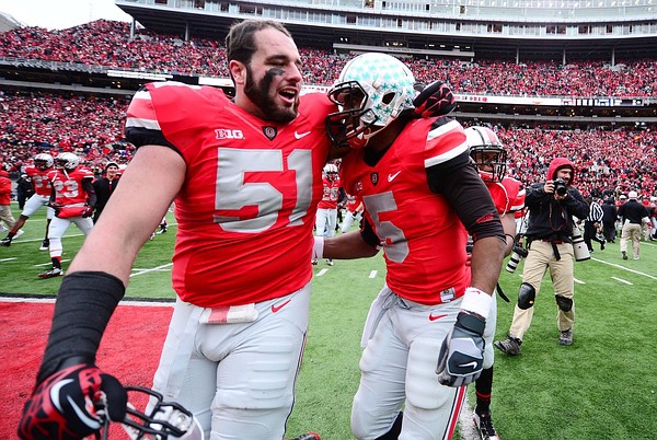 Nov 24, 2012; Columbus, OH, USA; Ohio State Buckeyes defensive tackle Joel Hale (51) celebrates with teammate Braxton Miller (5) after defeating the Michigan Wolverines 26-21 to go undefeated on the season at Ohio Stadium. Mandatory Credit: Andrew Weber-US PRESSWIRE