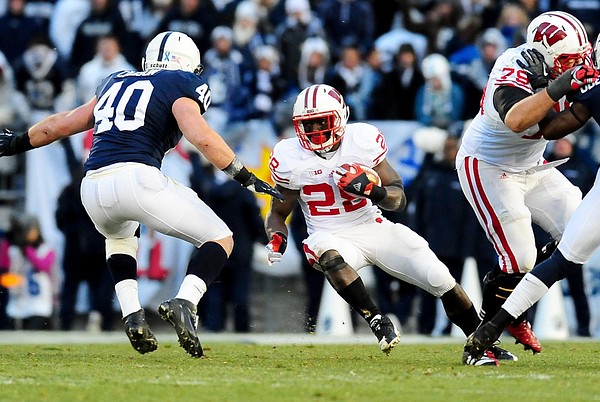 November 24, 2012; University Park, PA, USA;Wisconsin Badgers running back Montee Ball (28) runs with the ball while being pursued by Penn State Nittany Lions linebacker Glenn Carson (40) at Beaver Stadium.