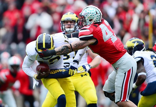 Nov 24, 2012; Columbus, OH, USA; Michigan Wolverines quarterback Devin Gardner (12) is sacked by Ohio State Buckeyes defensive lineman Nathan Williams (43) in the fourth quarter at Ohio Stadium. Mandatory Credit: Andrew Weber-US PRESSWIRE