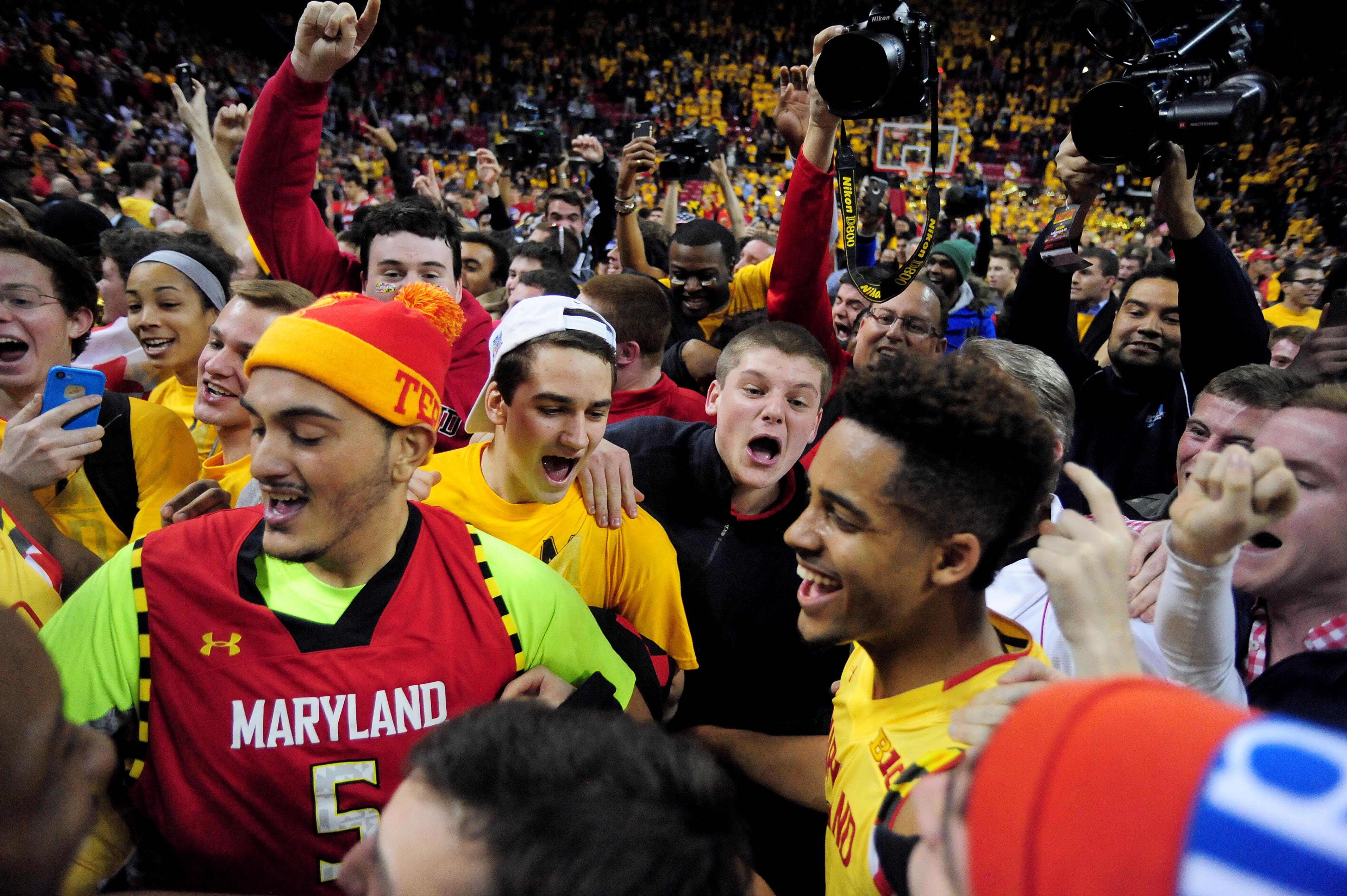 Maryland basketball fans rush court after win over Wisconsin.