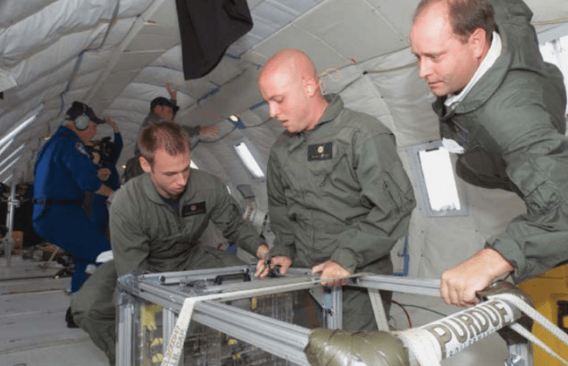 Callicot (right) doing experiments on board the "Vomit Comet," a NASA plane that simulates the zero-gravity environment.