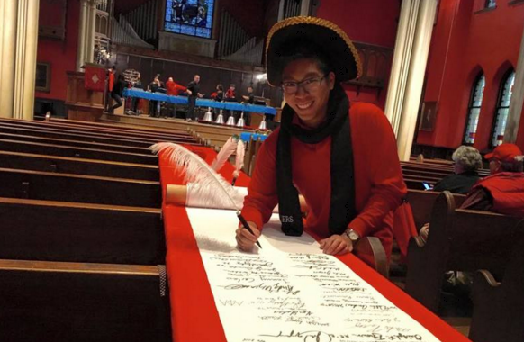 Student Rendell Tababan "makes a mark" on Rutgers history by signing the 250th anniversary commemorative scroll.