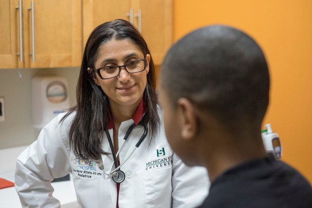 MSU's Dr. Hanna-Attisha chats with 9 year-old Jaquan during an examination. Photo courtesy of Michigan State