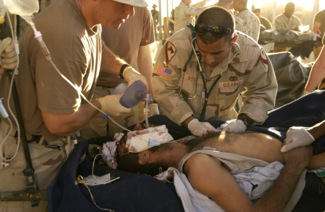 Dr. Bose (at right) treats an Iraqi in the aftermath of the bombing.