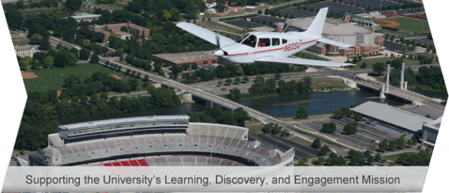 A plane flies over the Ohio State University Stadium, the "Horseshoe"