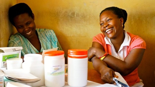 Nurses share a laugh near some medical supplies