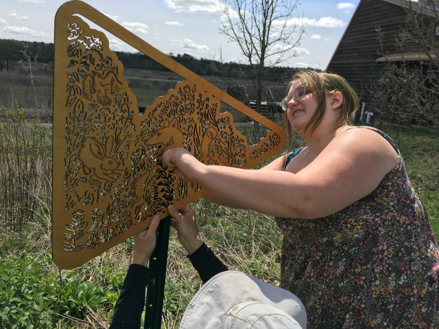 University of Wisconsin artists Liza Anna Kozik installing part of her prairie art exhibit.