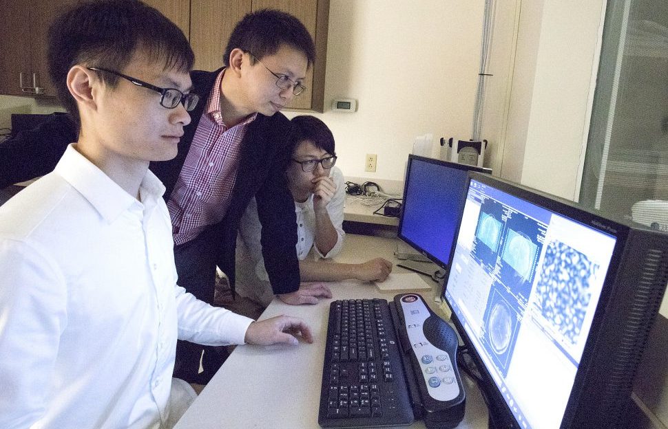 From left, doctoral student Haiguang Wen, assistant professor Zhongming Liu and former graduate student Junxing Shi, review fMRI data of brain scans. The work aims to improve artificial intelligence and lead to new insights into brain function. (Purdue University image/Erin Easterling)