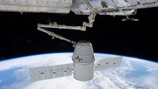 A SpaceX Dragon Capsule attached to the International Space Station by the Canadarm