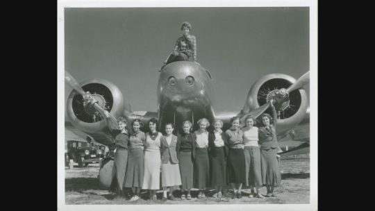 Amelia Earhart a a group of women in front of one of her planes