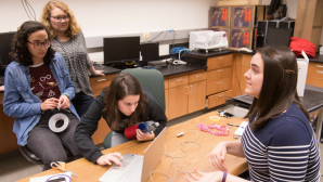 As part of their senior design course, biomedical engineering students (from left) Anna Rodriguez, Maria Fernanda Larraga Martinez, Ashten Sherman, and Genevieve Goelz created the GAMA bra, a compression garment that can be worn by breast cancer patients after a unilateral mastectomy. The garment could help thousands of patients avoid painful swelling associated with lymphedema. Here, the team uses a filler substance to help give their modified mannequin a more lifelike feel in terms of weight and rigidity. Photo by Tim Schoon.