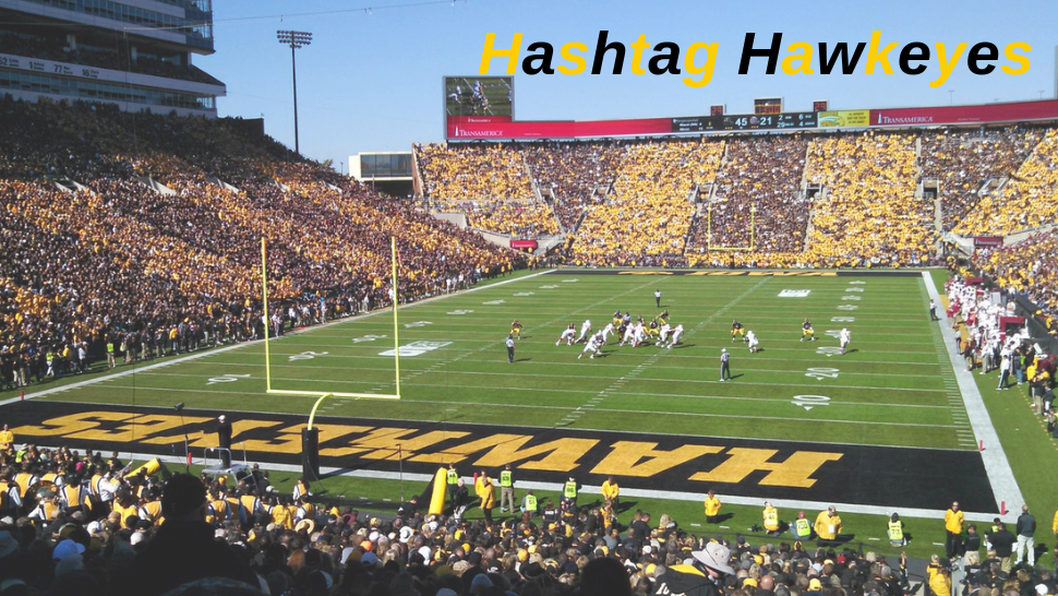 Hashtag Hawkeyes overlayed on an image of a University of Iowa Football Game
