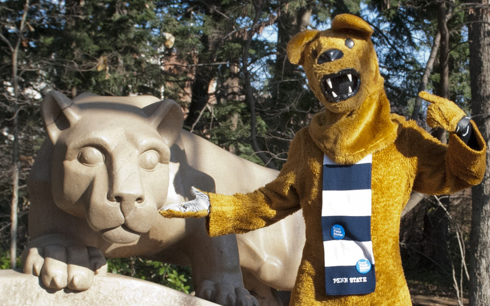 The Nittany Lion mascot visits the Nittany Lion statue. Penn State's University Park campus, Dec. 2012