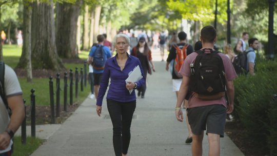 Penn State professor of anthropology Nina Jablonski walking on campus ina large group of people