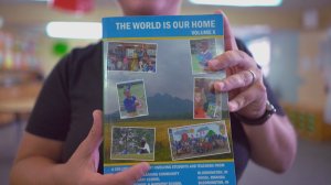 Vera Marinova holds a copy of the Indiana University anthology The World is our Home created by the Books and Beyond program.